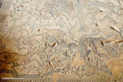 A partially-eroded mosaic depicting the Nile River, predators (such as lions), prey (such as deer), flowering plants, horsemen, and a tower-shaped structure